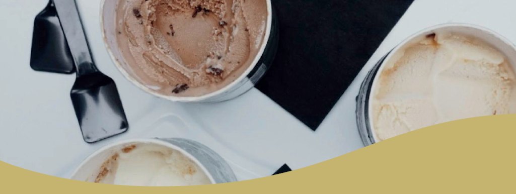 Open tubs of ice cream photographed from above with serving spatulas