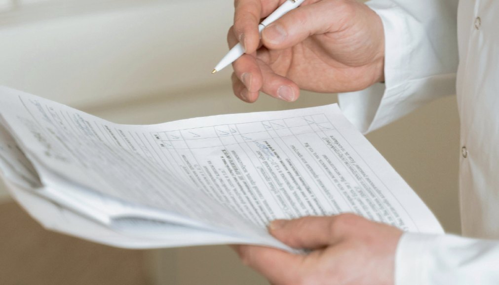 A judge marking a scoring sheet with a pen